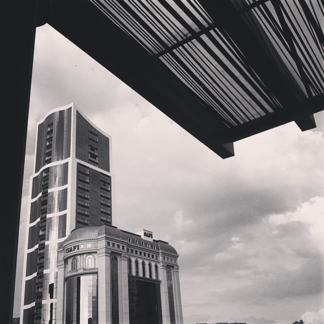 a black and white po of an outside building with a cloudy sky in the background