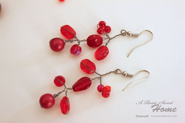 red beads hang from shiny silver colored ear wires