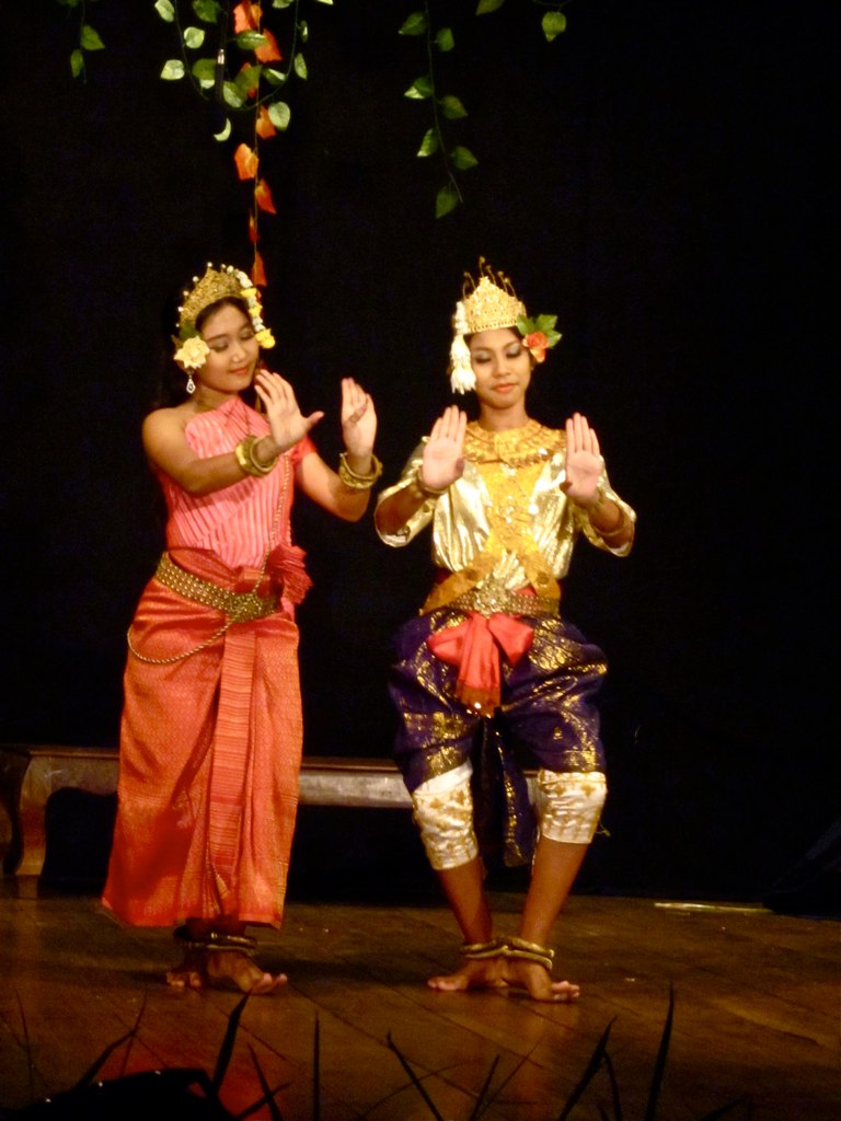 two female dancers performing on stage with decorated tree nches overhead