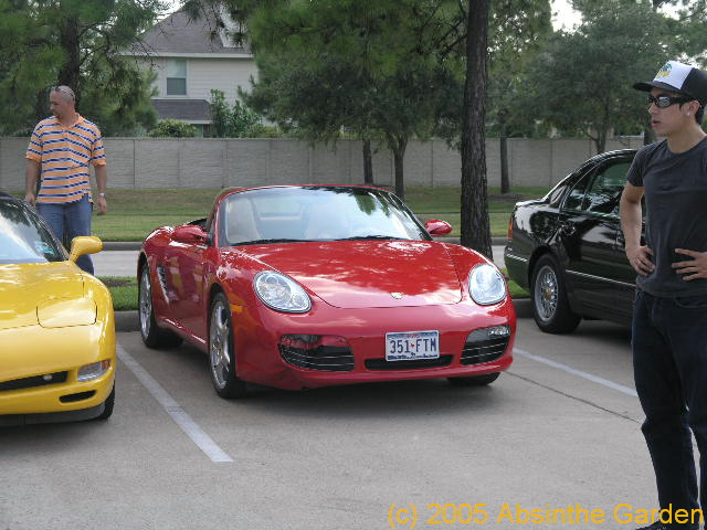 a group of people stand around some cars