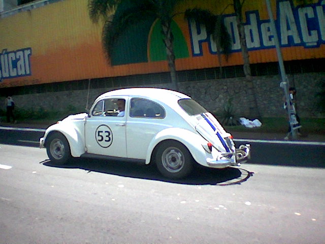 an antique race car sitting on the side of the road