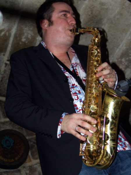 a man holding onto the side of a golden saxophone