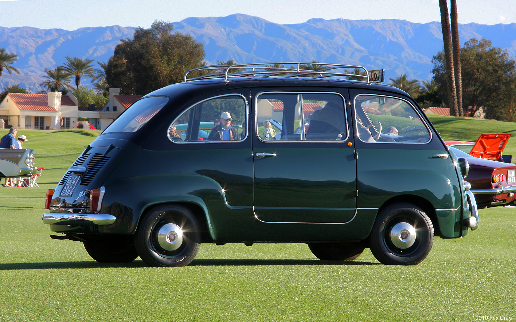 a classic mini car with a rooftop rack and a luggage carrier