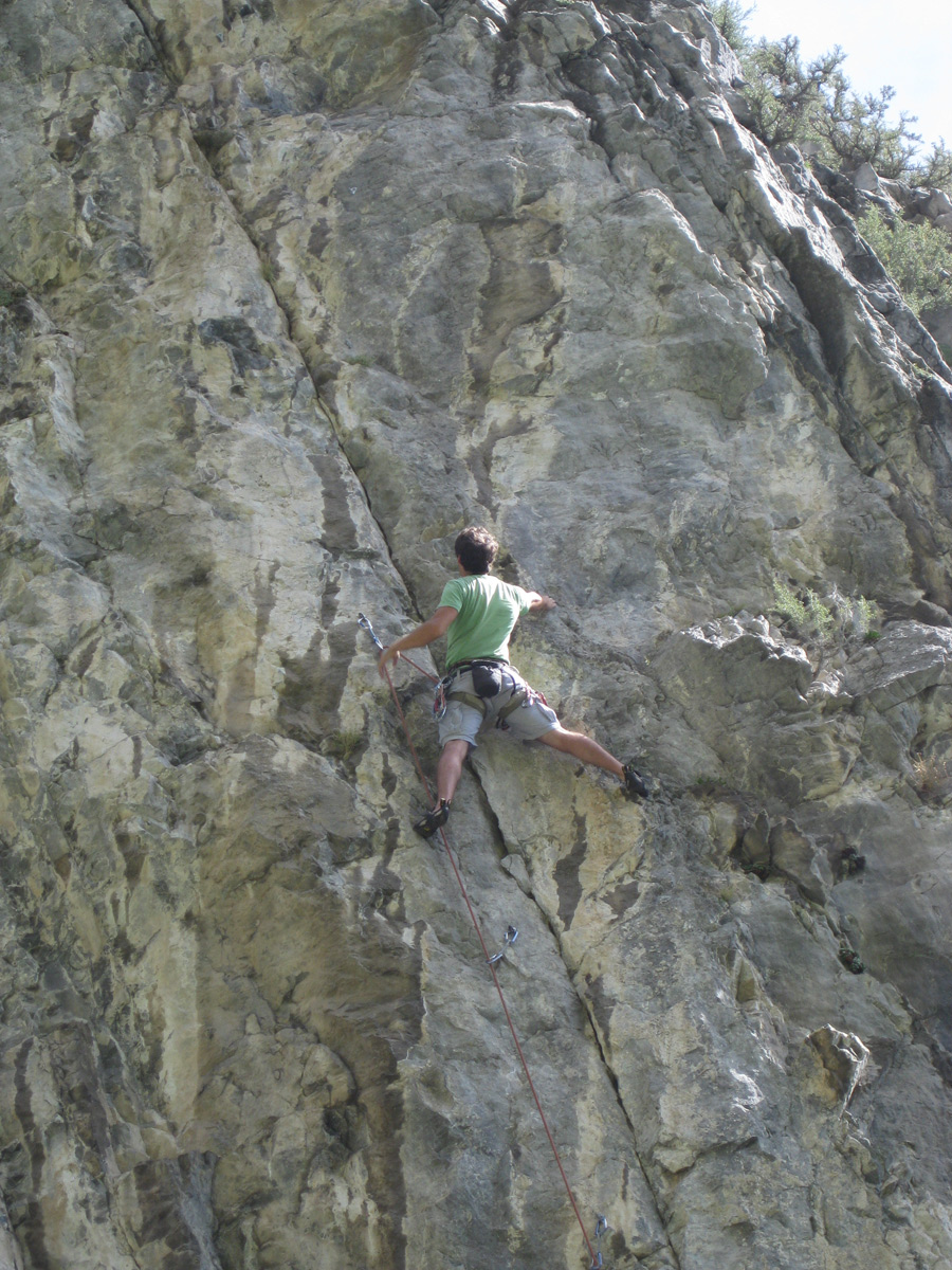 someone climbing up an almost empty rock face