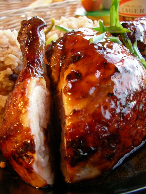 a close up of a chicken on a plate with rice