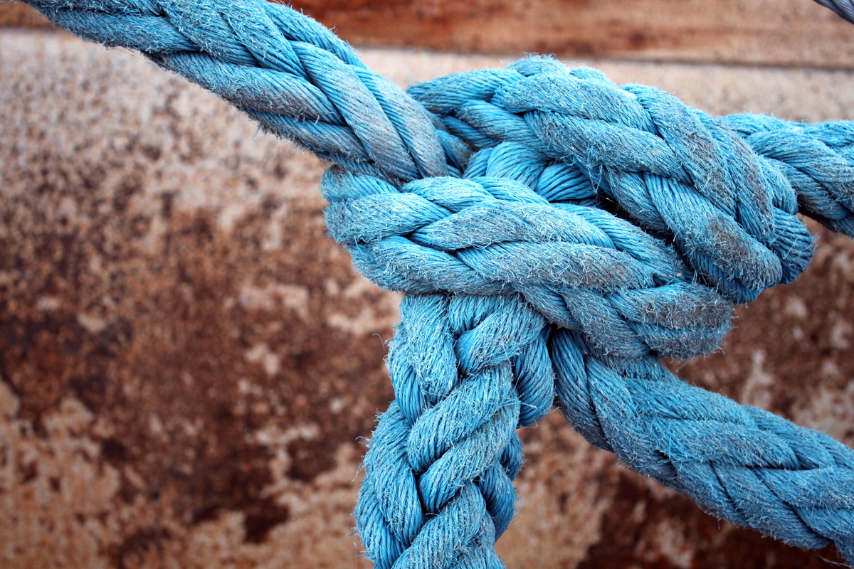 a blue rope attached to a metal wall