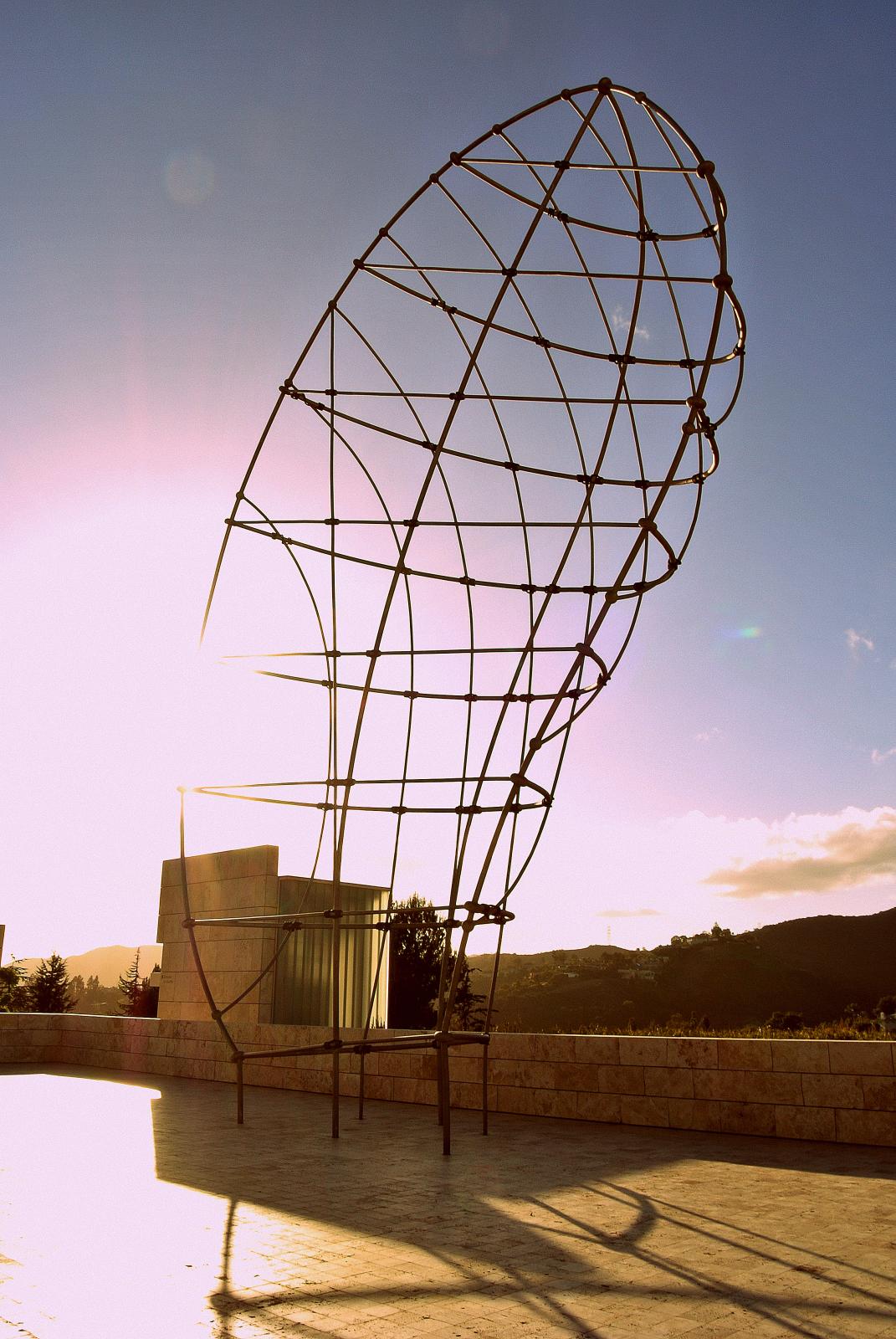 a metal sculpture sitting on the side of a road