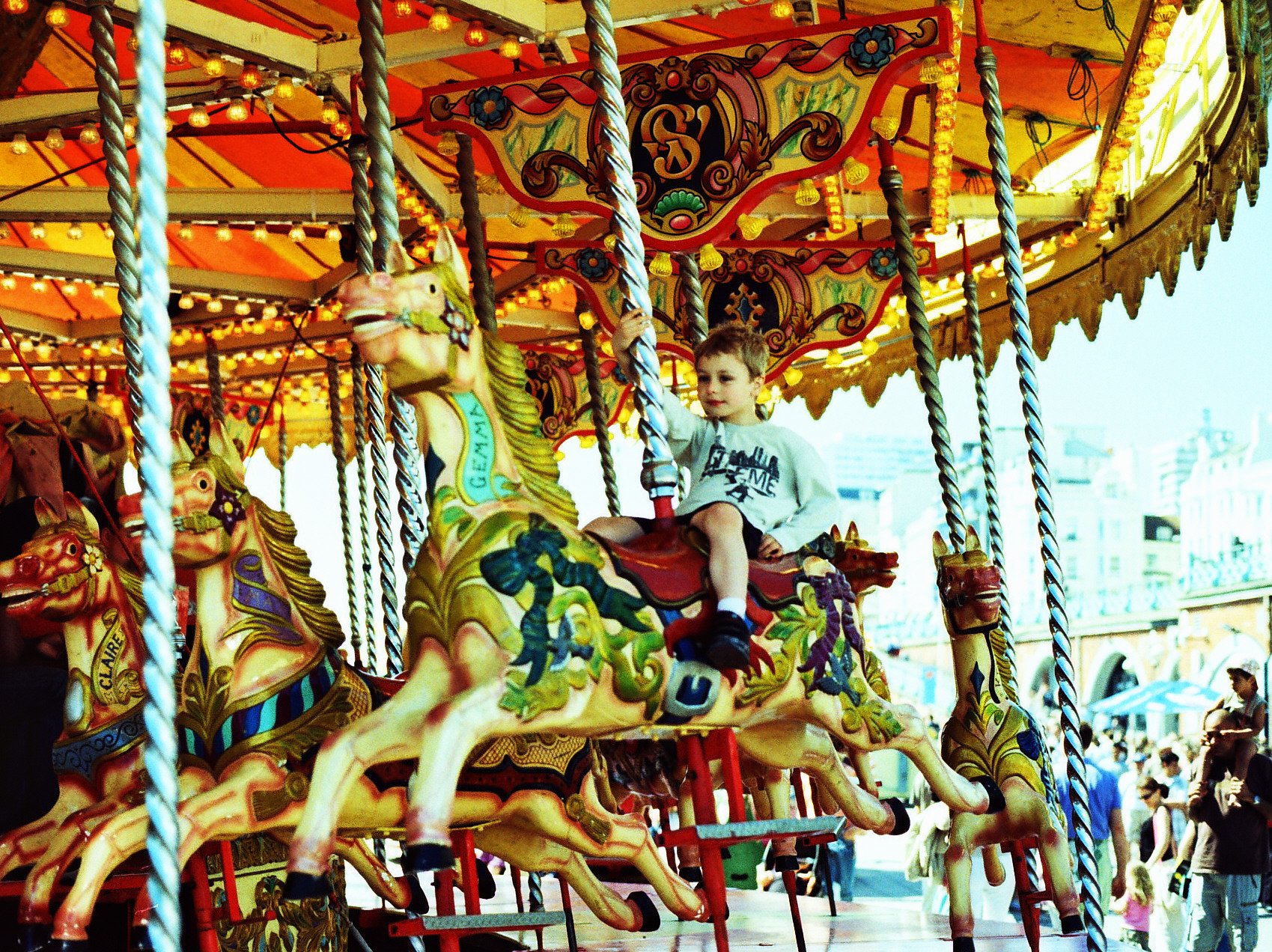 boy sitting on a carousel at a fairground