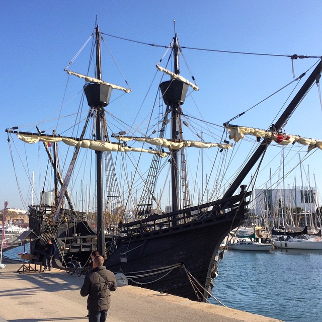 people stand near a large boat parked at the dock