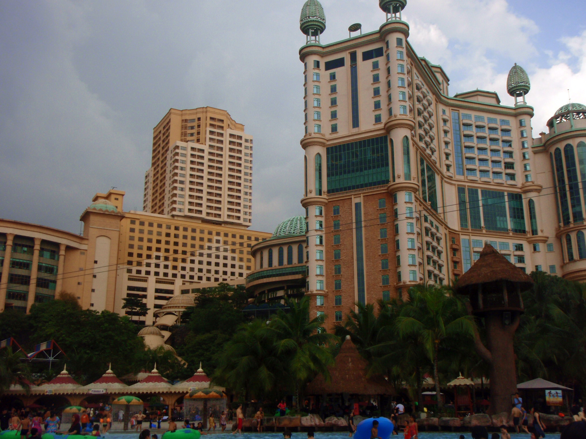 a large building next to a pool with people in it