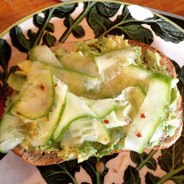 a plate filled with sandwiches topped with cucumbers