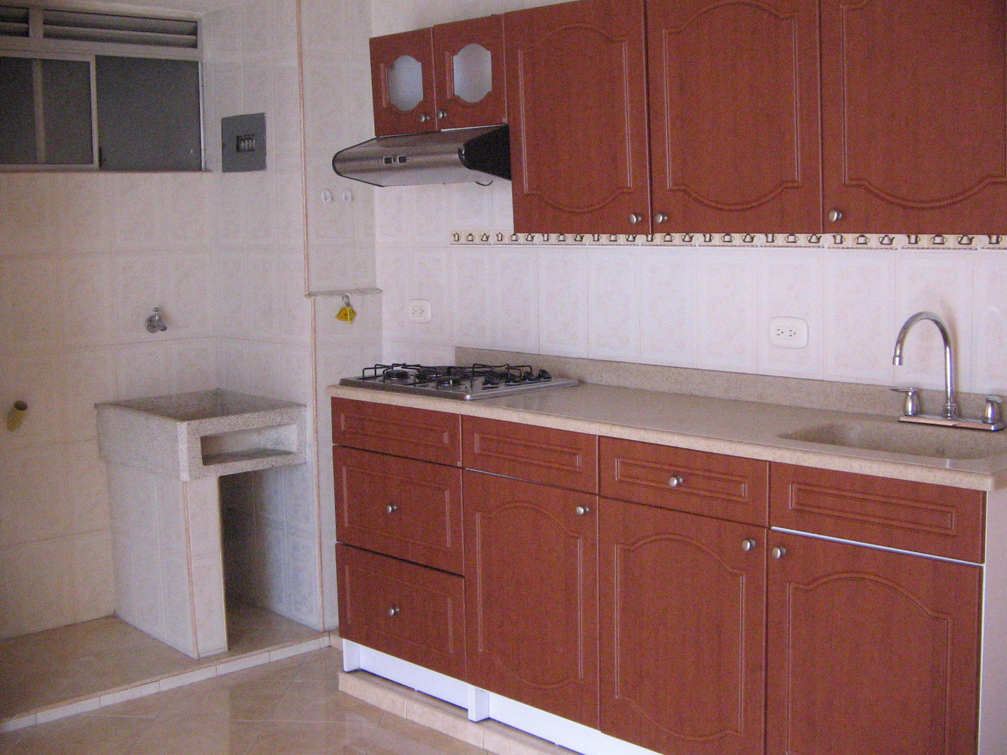 a small kitchen has brown cabinets and white walls