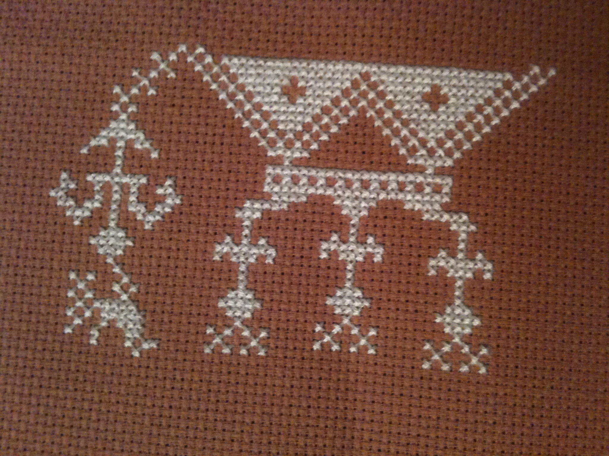 a cross stitch pattern on a piece of fabric
