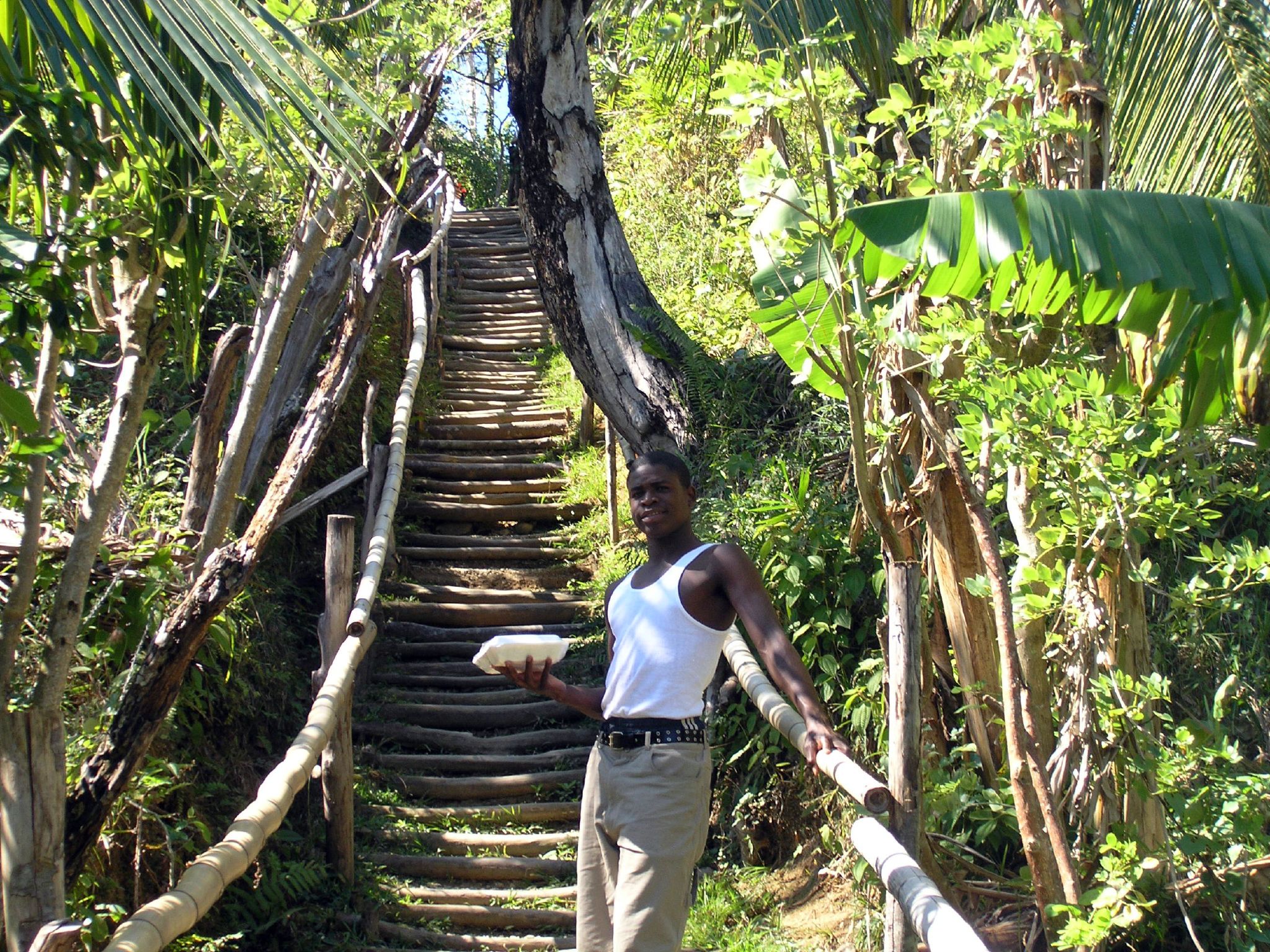 a man holding an object while standing on the edge of a stairs