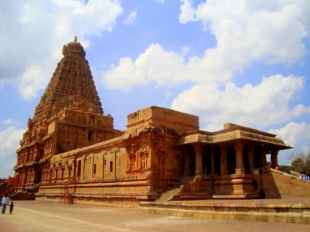 a large brown stone building with pillars under a blue sky