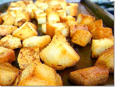 pan filled with bread croutons and seasoning on a counter