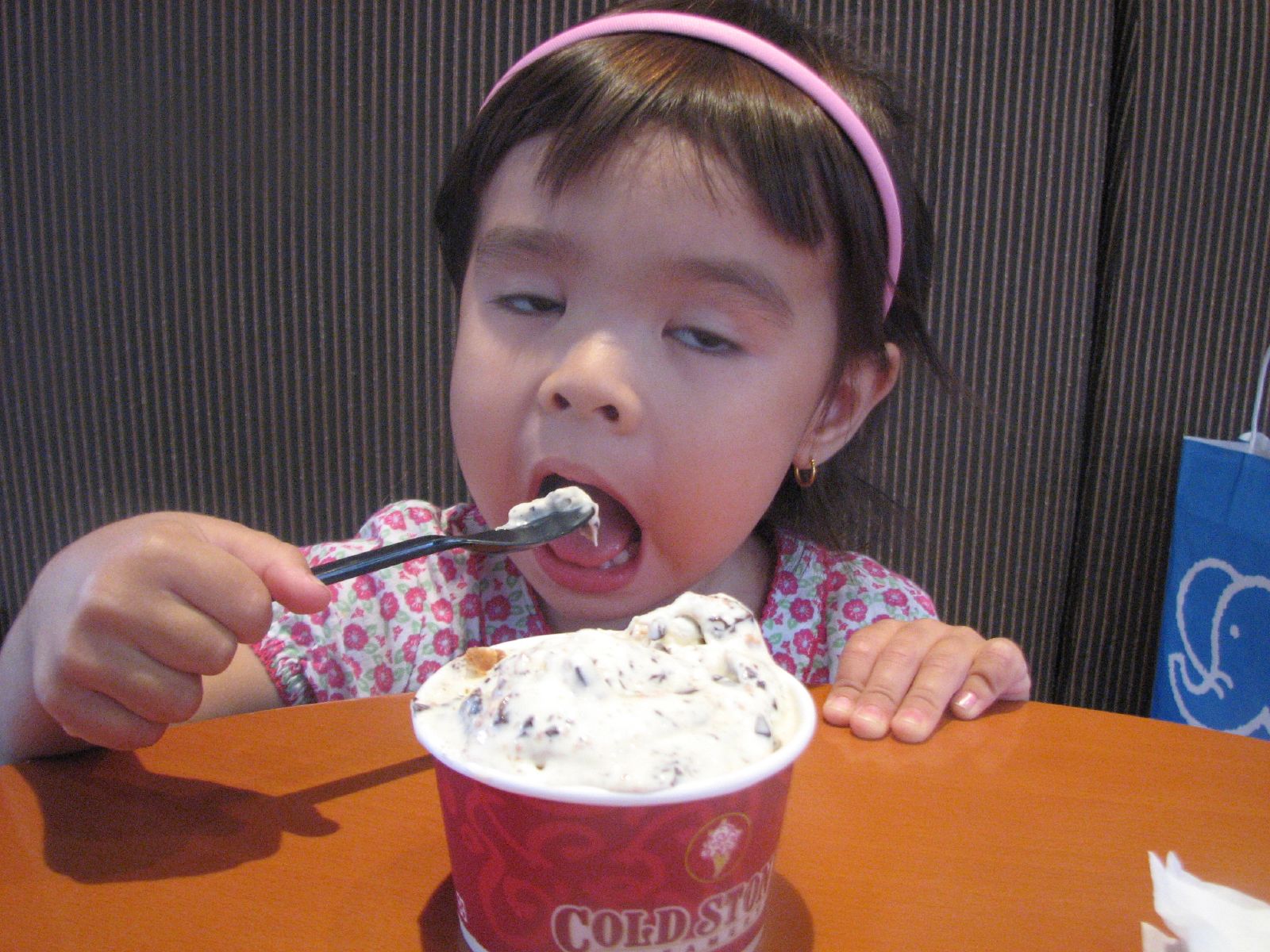 a girl holding a spoon full of ice cream