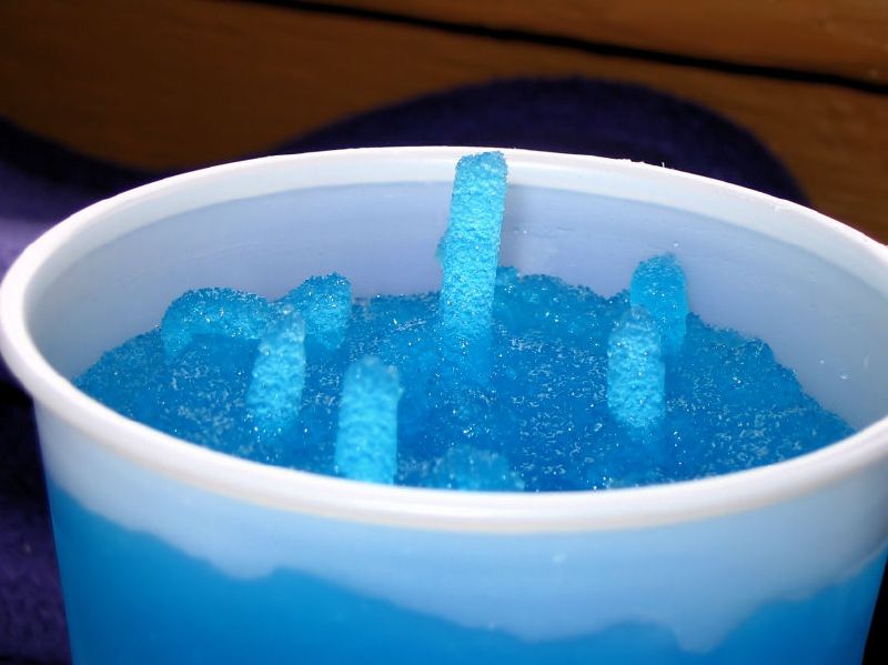 a blue drink is being poured into an ice bucket