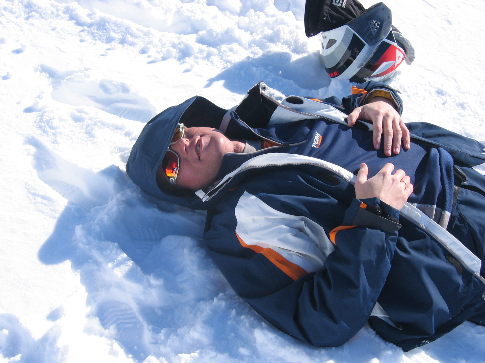 a man lays in the snow wearing some ski equipment