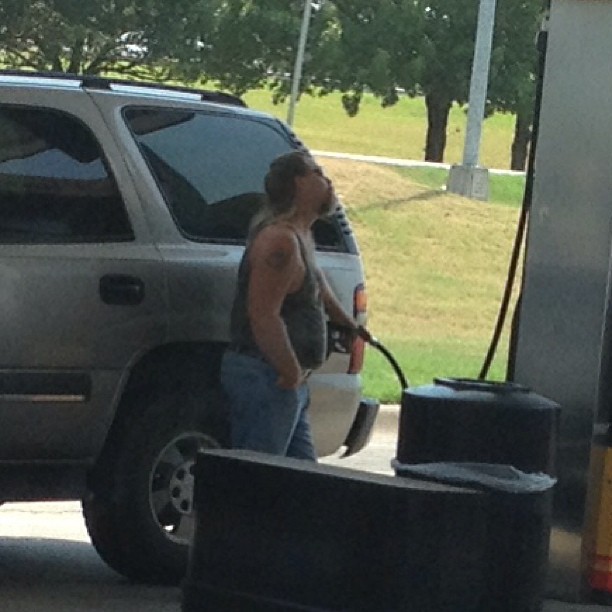 the man is filling his truck with a gas