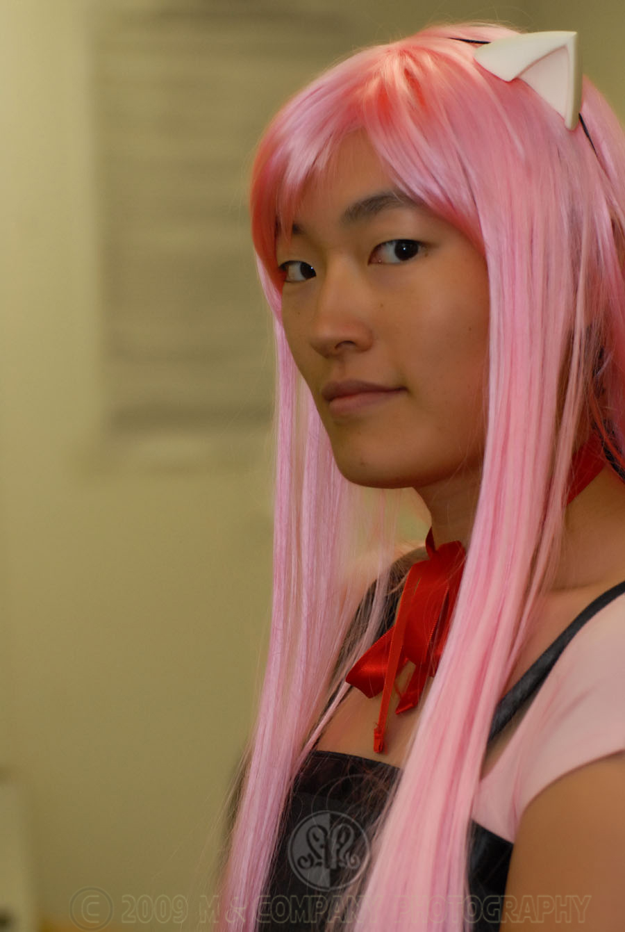 a woman with pink hair and bangs wearing a bow