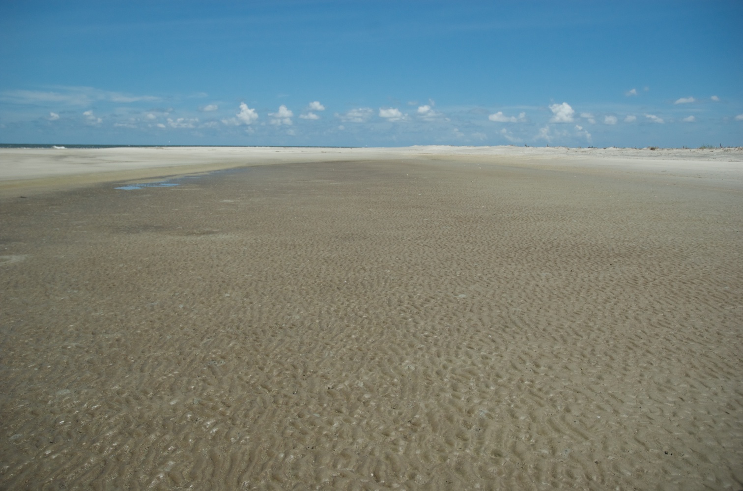 there is an empty beach with water and sand