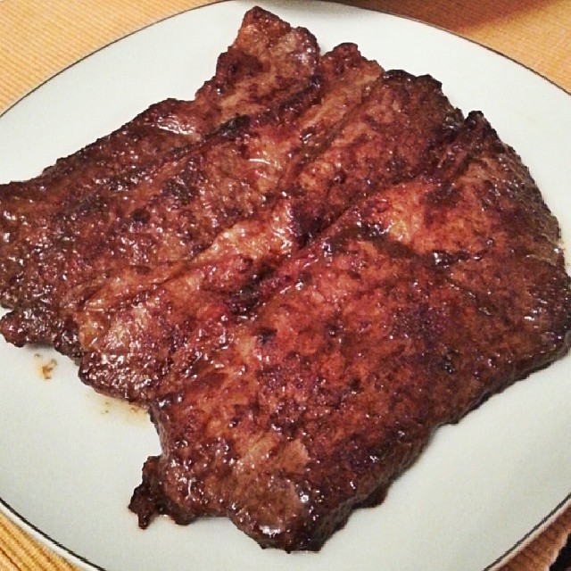 a bunch of beef chops that are sitting on a white plate