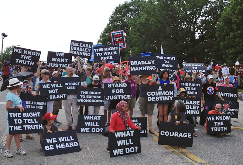 protesters stand in the street with signs