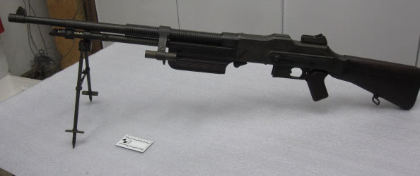 an automatic rifle with a gun and scope on display