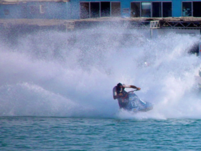 an extreme wakeboarding in the ocean with smoke coming from the rear of it