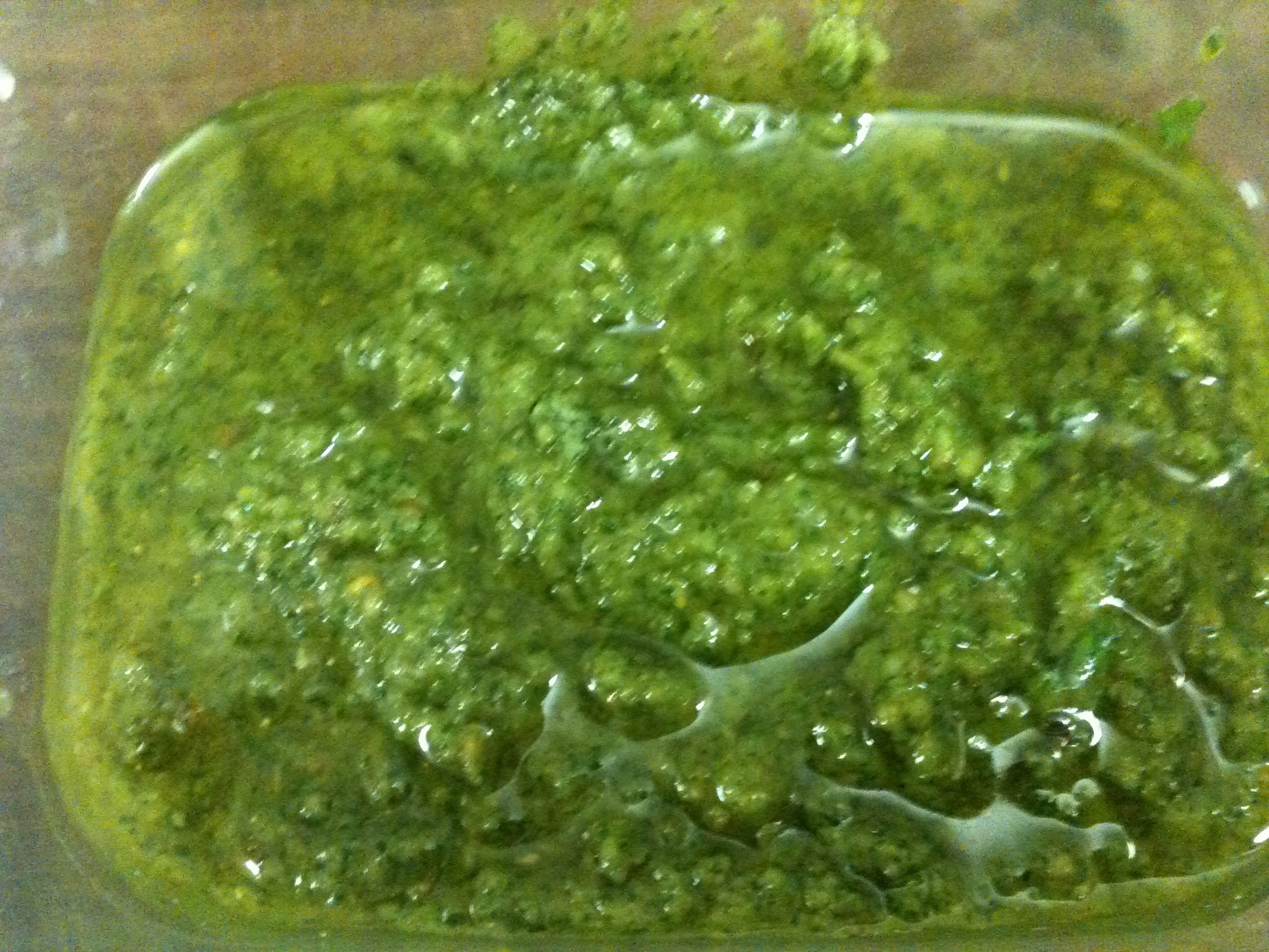 a green sauce sits in a bowl on a counter