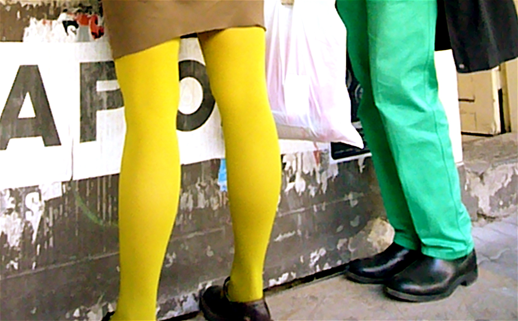two mannequins in green and yellow are dressed in tight clothing
