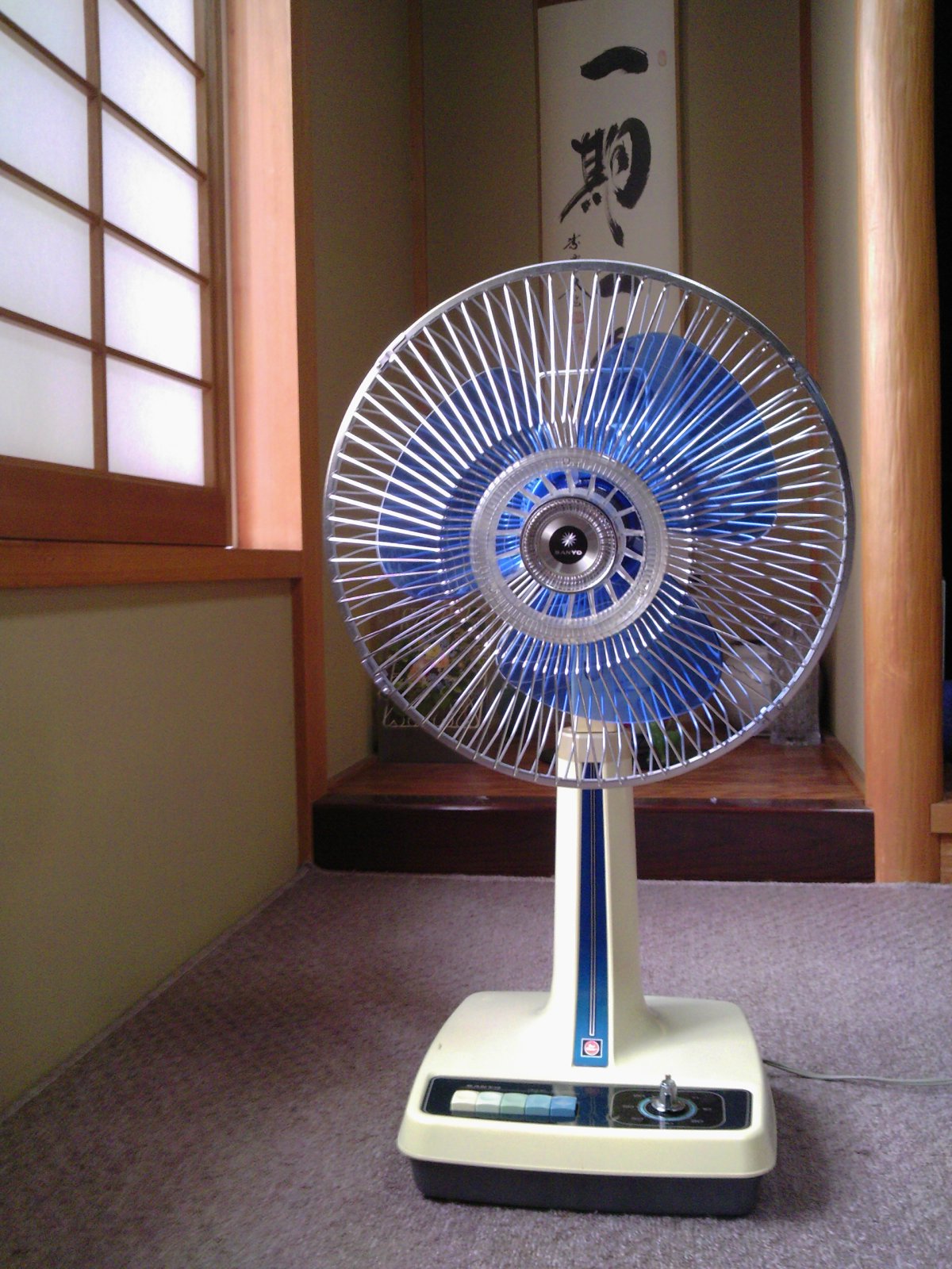 a fan with a clock in the corner