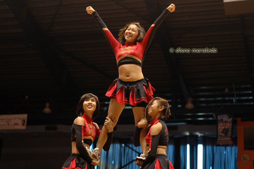 three girls standing in the air with their arms raised