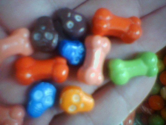 a person's palm holding tiny assorted candy dogs