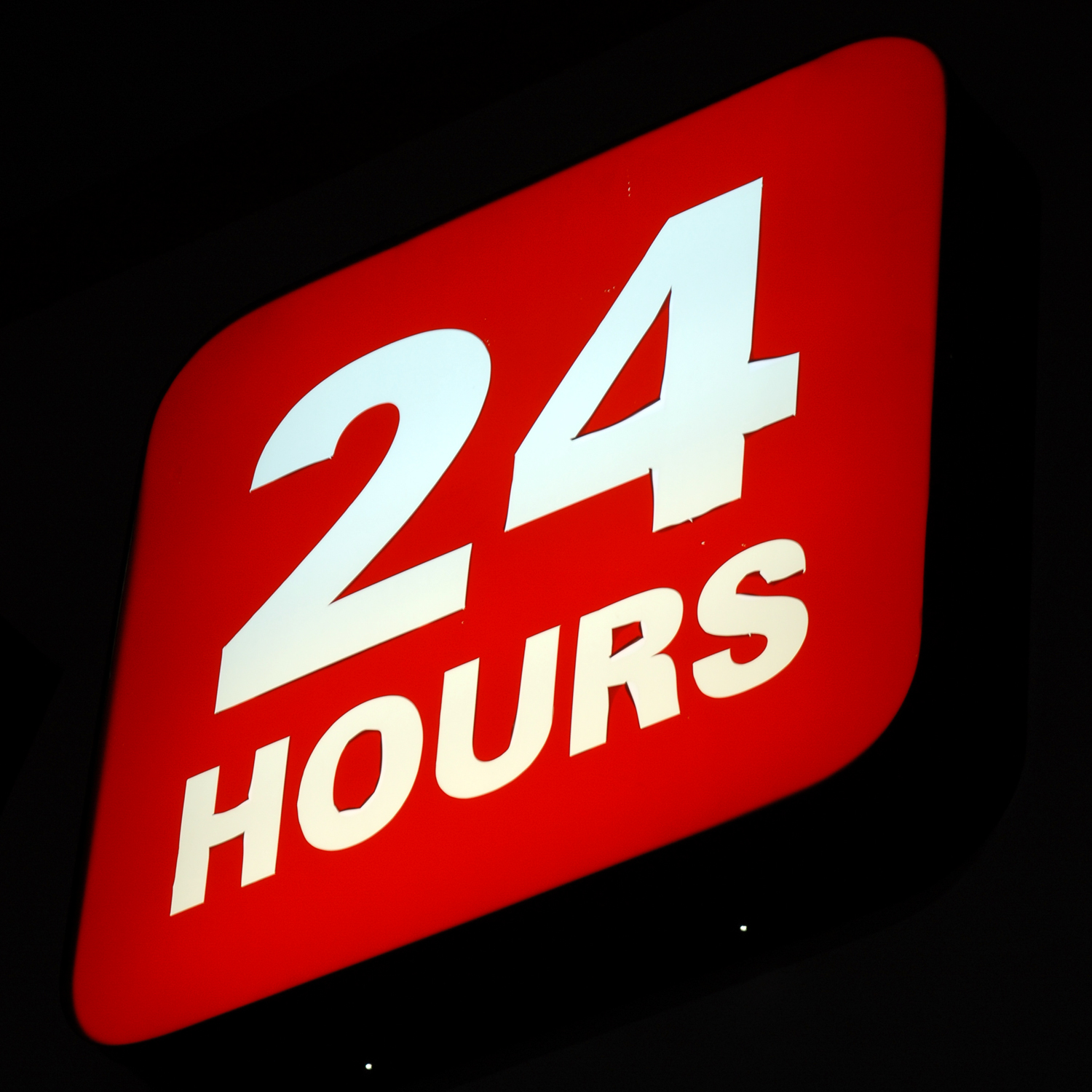 a red sign reading 24 hours with white lettering