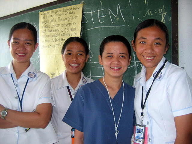 several young people in scrubs standing in front of a chalk board