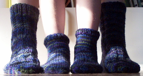 two legs wearing socks made from crochet wool