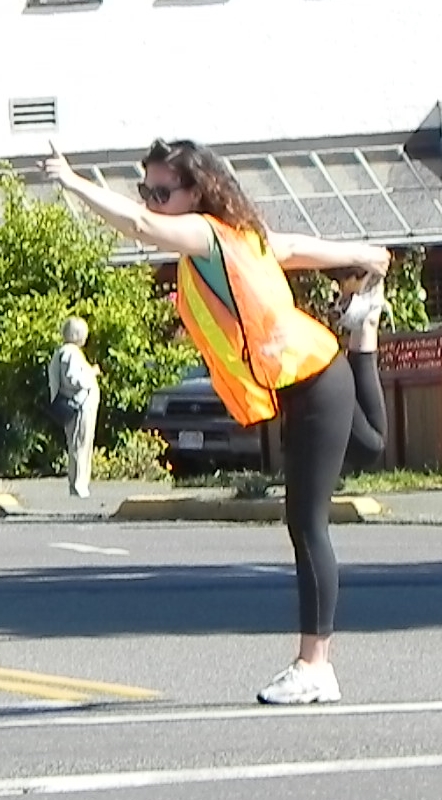 a woman is dancing in the middle of a street