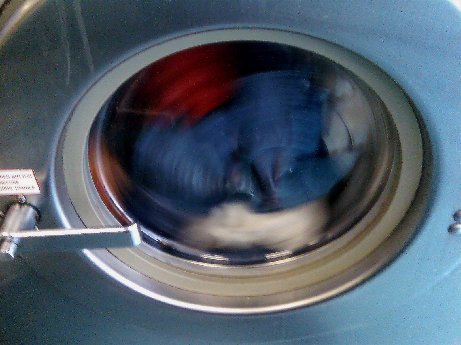 a man wearing a blue shirt looking inside of a washing machine