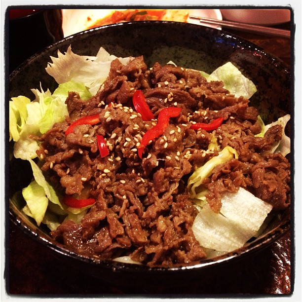 this is an asian beef salad in a bowl