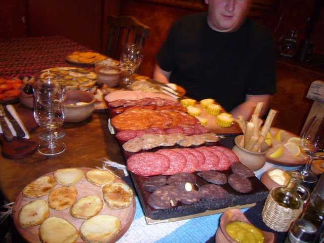 a table with several different platters of foods and a guy