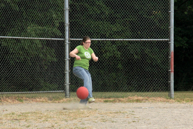 a person on a field with a ball and a fence