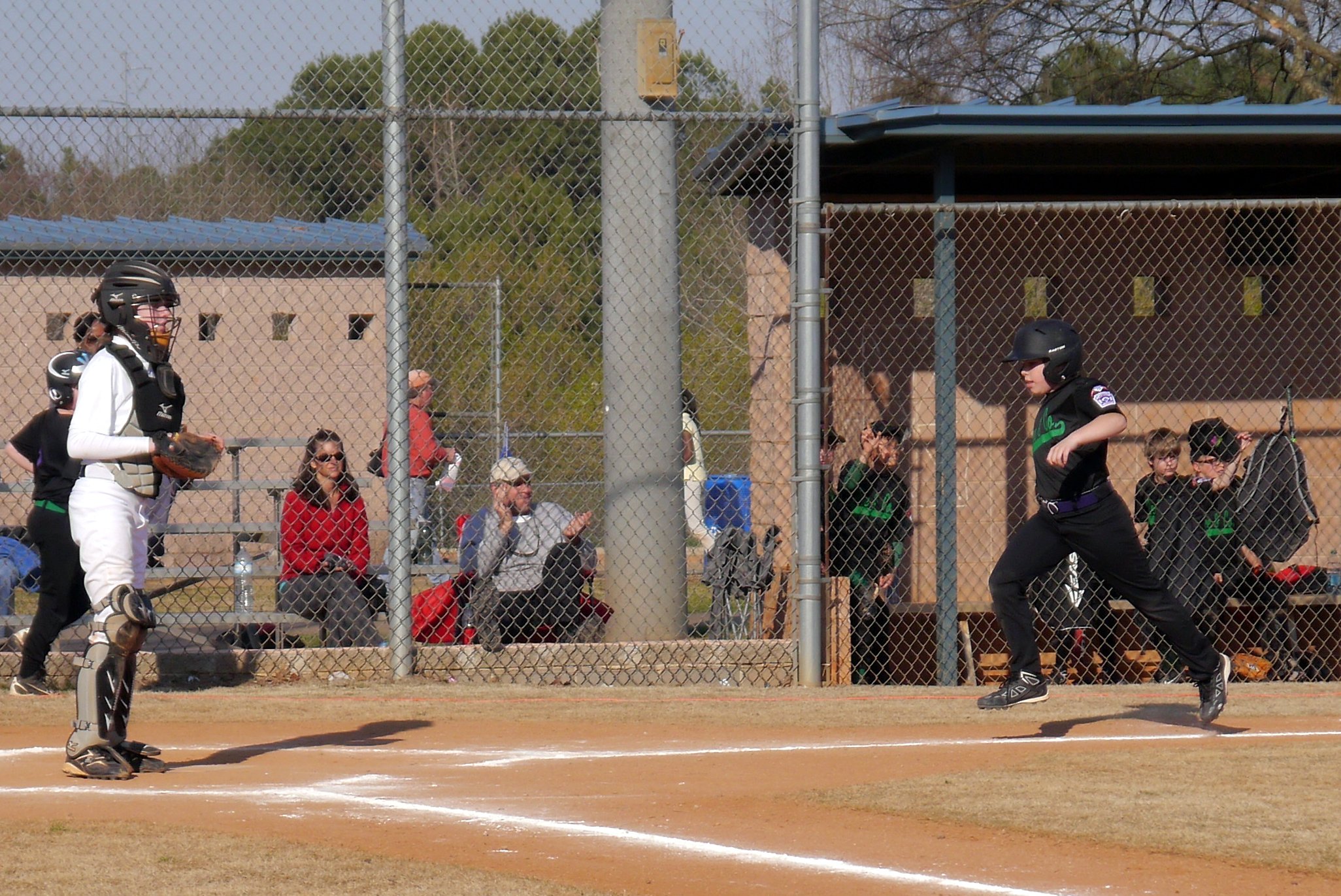 a boy swinging at a baseball during a game