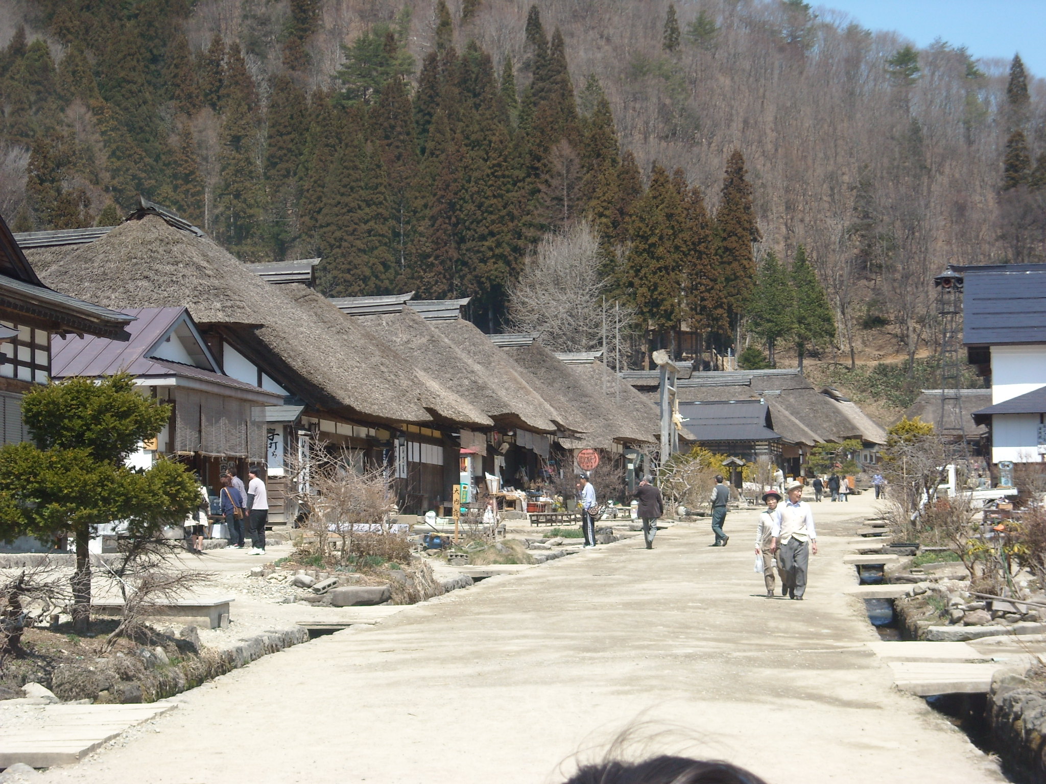 a village has a stone walkway surrounded by huts