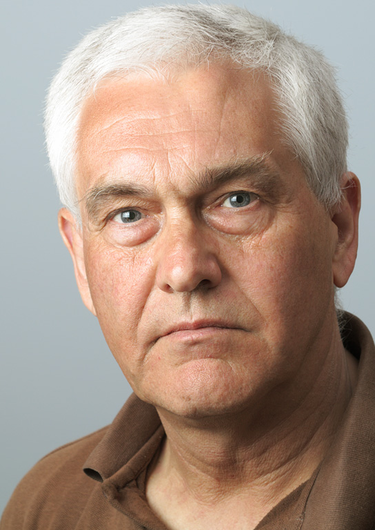 a man with white hair has a serious look on his face