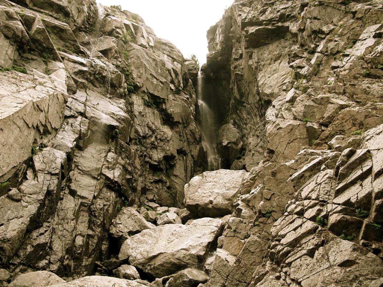 a view from the bottom of a mountain with a waterfall