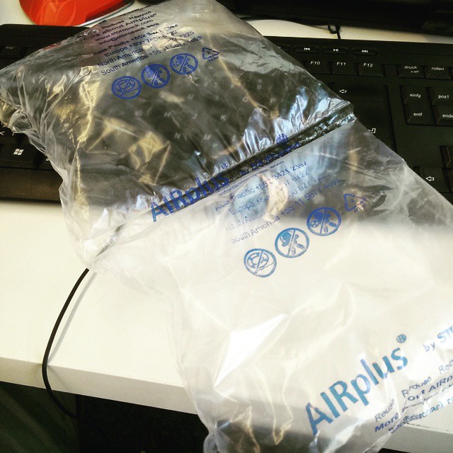 two plastic bags containing a keyboard, a red ball and some wires