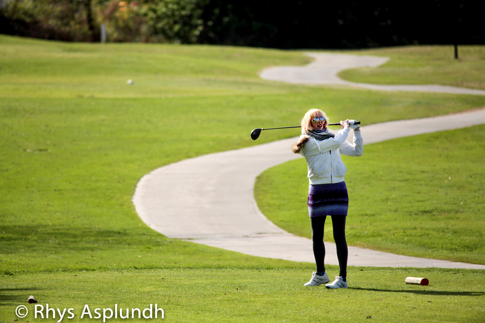 a women who is playing golf on the course