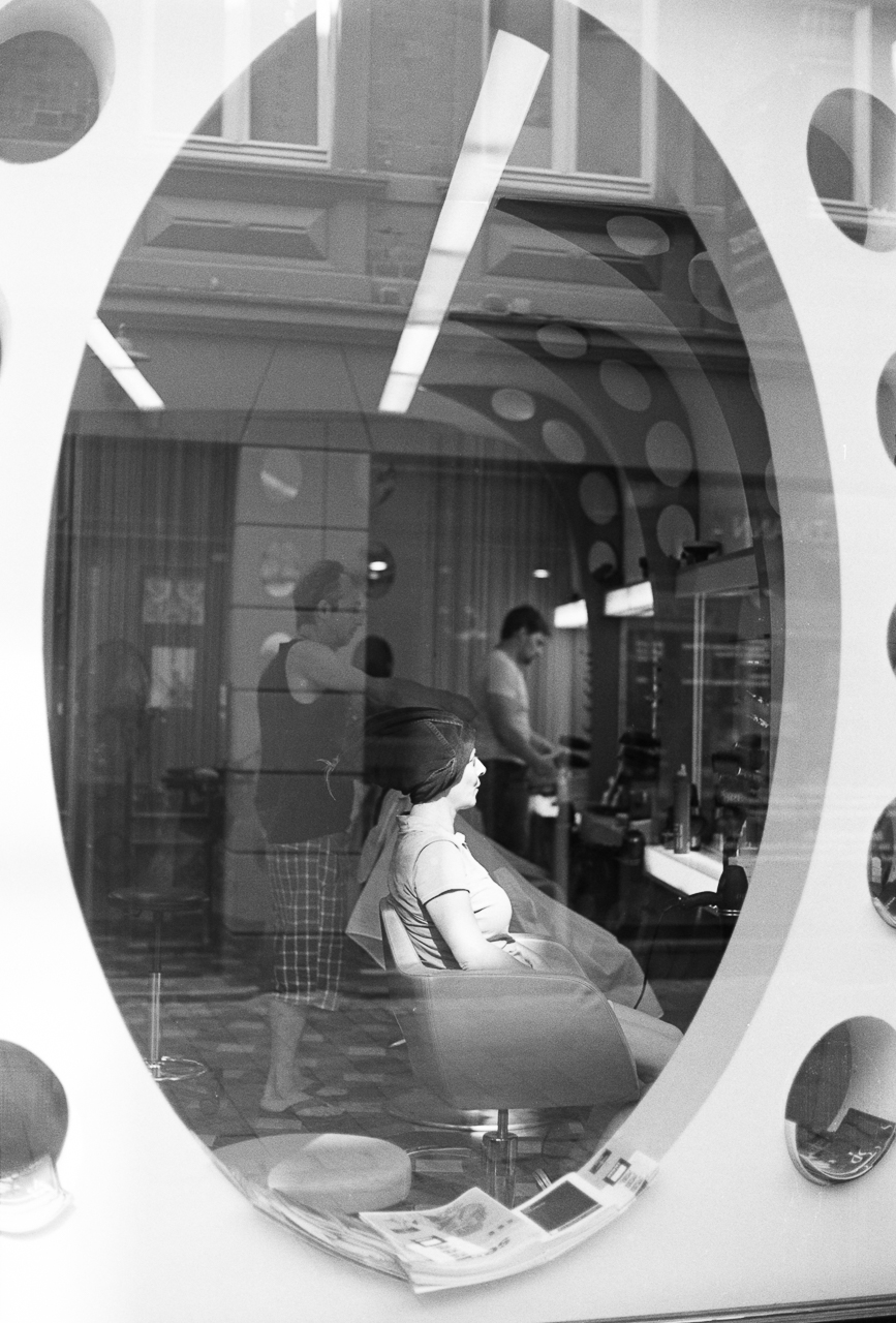 a woman is sitting in front of a round mirror